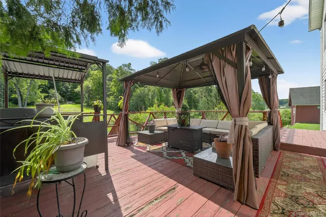 a view of a patio with table and chairs potted plants with wooden floor and floor to ceiling window