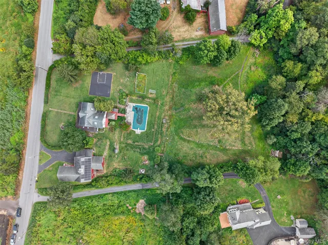 a aerial view of a house with swimming pool next to a yard
