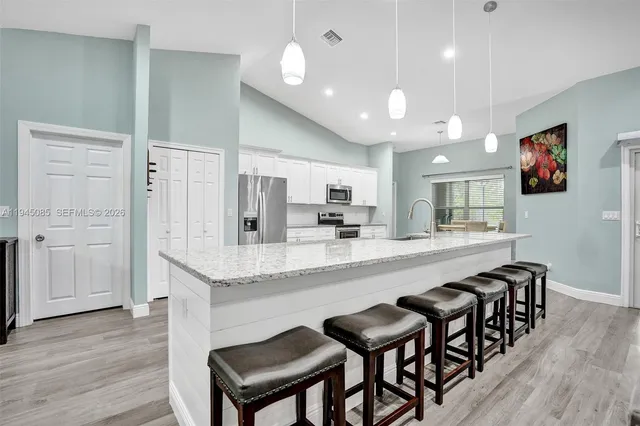a large kitchen with lots of counter space and chairs