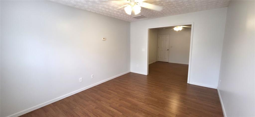 89 Savannah Lane Jefferson, GA 30549 - Photo 13 of 19 an empty room with wooden floor and chandelier fan