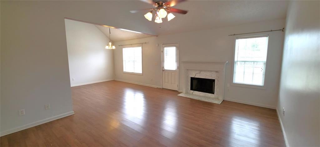 89 Savannah Lane Jefferson, GA 30549 - Photo 3 of 19 an empty room with wooden floor fireplace and windows