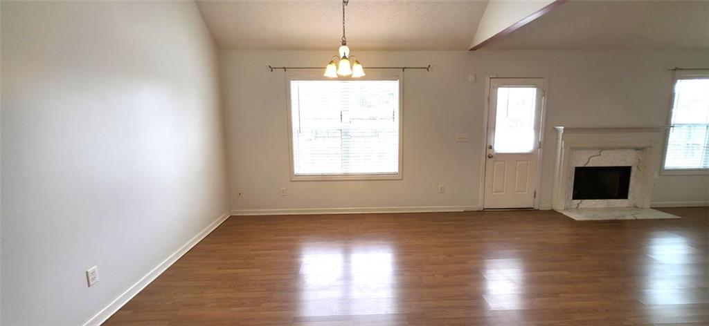 89 Savannah Lane Jefferson, GA 30549 - Photo 4 of 19 an empty room with wooden floor fireplace and windows