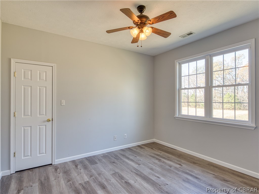 921 Buckley Hall Road Dutton, VA 23050 - Photo 32 of 42 an empty room with a window and a fan