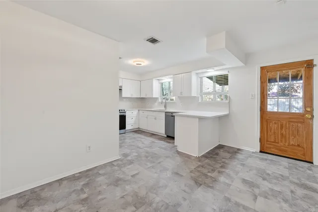 a kitchen with cabinets appliances a sink and a window