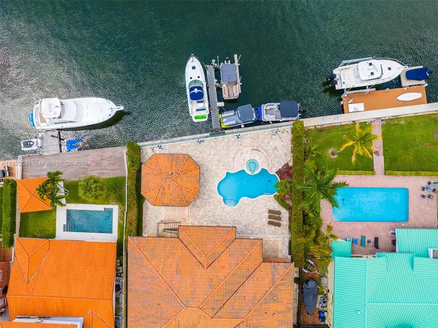 a aerial view of a house with swimming pool patio and outdoor seating
