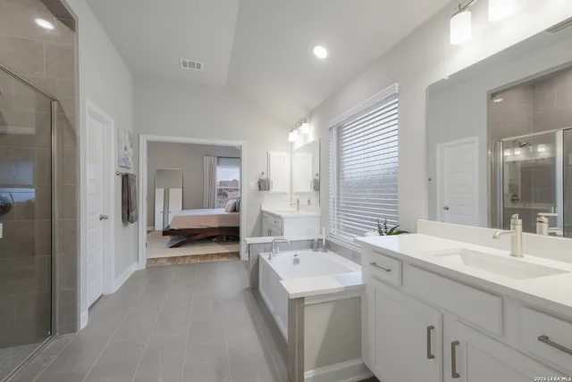 a en suite bathroom with a double vanity sink a mirror and a shower