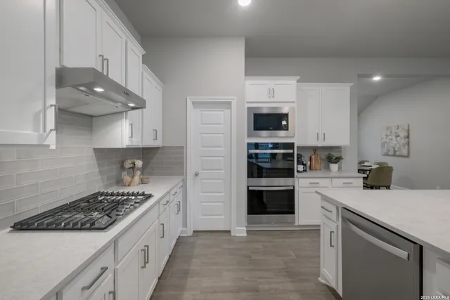 a kitchen with stainless steel appliances a stove sink microwave and cabinets