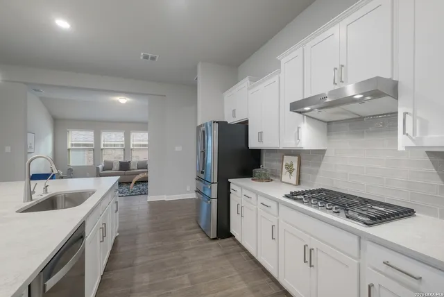 a kitchen with stainless steel appliances a sink stove and refrigerator