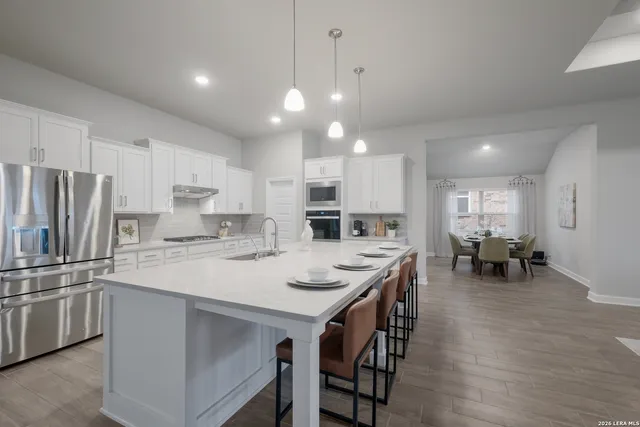 a kitchen with counter space dining table and stainless steel appliances
