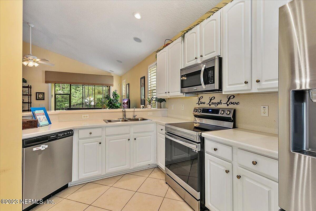 694 Copperhead Circle St. Augustine, FL 32092 - Photo 12 of 27 a kitchen with cabinets stainless steel appliances and sink