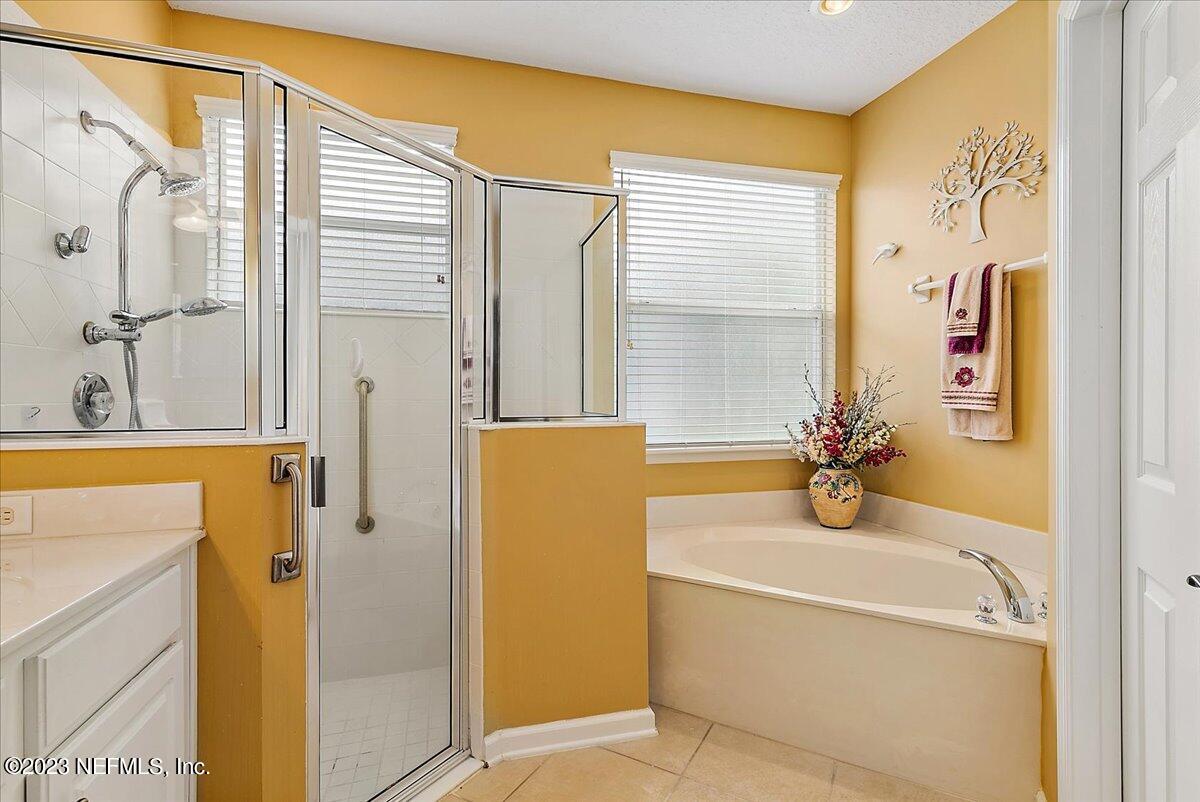 694 Copperhead Circle St. Augustine, FL 32092 - Photo 17 of 27 a bathroom with a tub sink and mirror