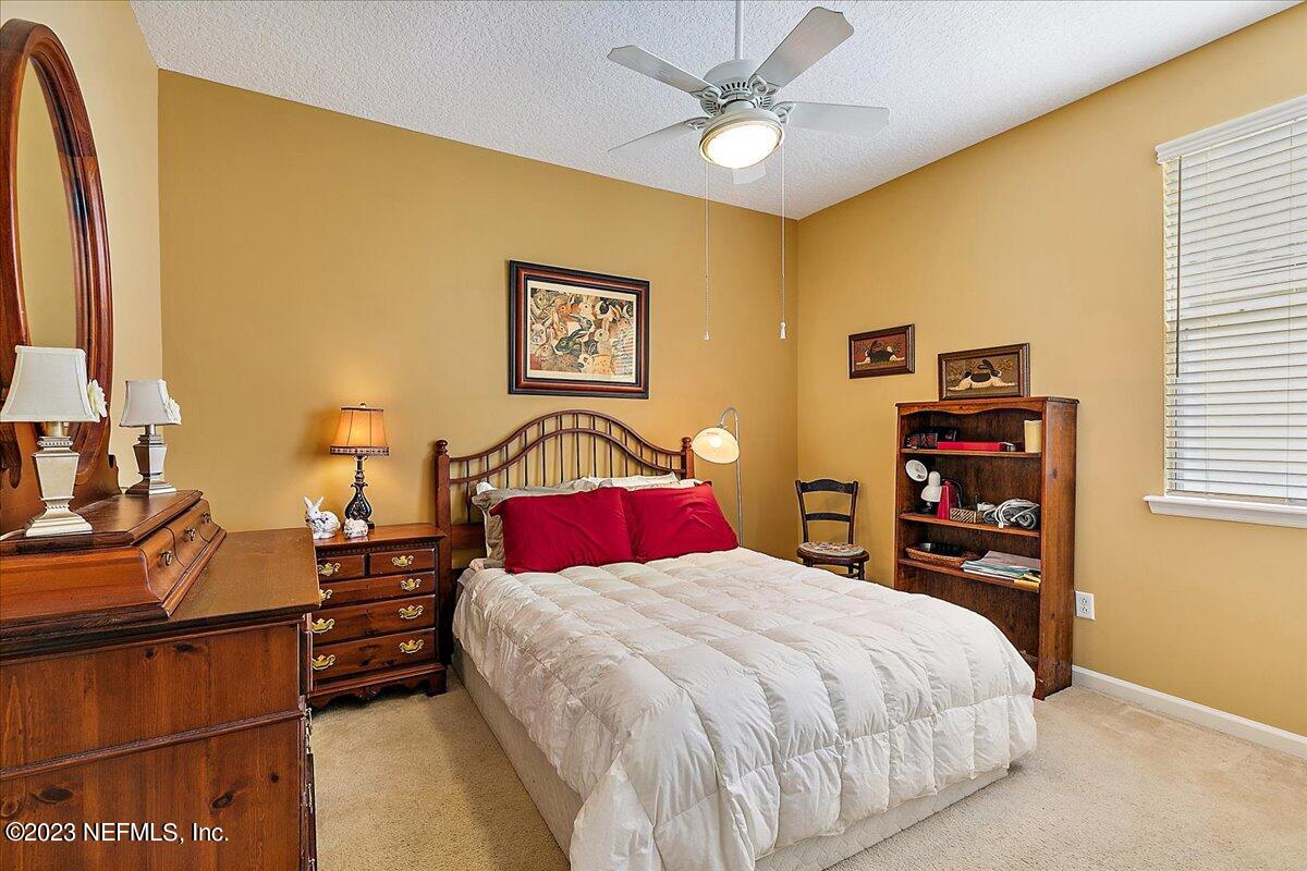 694 Copperhead Circle St. Augustine, FL 32092 - Photo 18 of 27 a bedroom with a bed and a chandelier