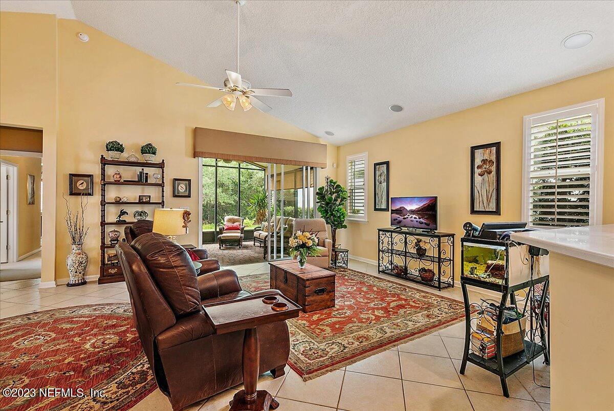 694 Copperhead Circle St. Augustine, FL 32092 - Photo 6 of 27 a living room with furniture a flat screen tv and a floor to ceiling window
