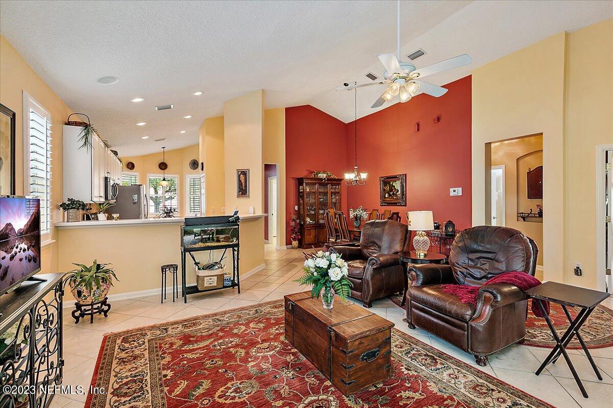 694 Copperhead Circle St. Augustine, FL 32092 - Photo 8 of 27 a living room with furniture a rug and a chandelier