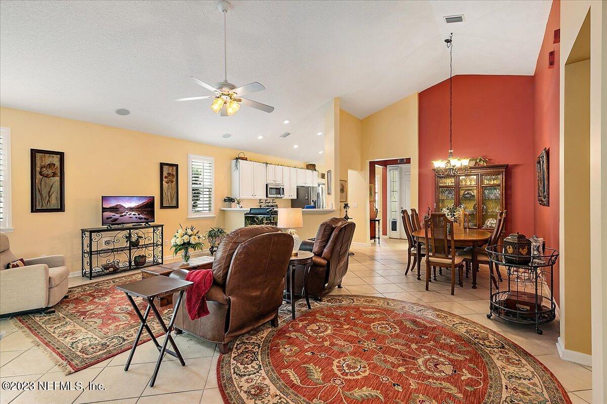 694 Copperhead Circle St. Augustine, FL 32092 - Photo 9 of 27 a living room with furniture a dining table a rug and a chandelier