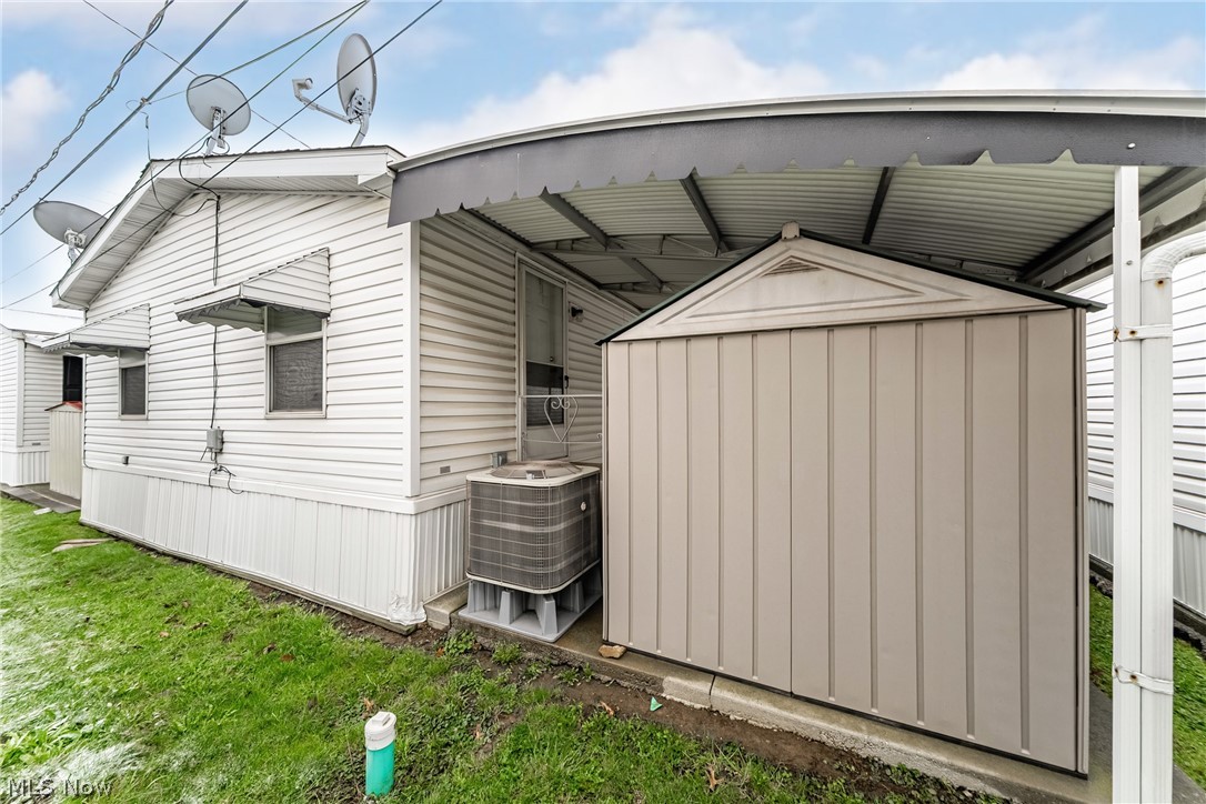 2700 Brookpark Road, Unit 513 Cleveland, OH 44134 - Photo 25 of 25 View of home's exterior with a storage unit and a lawn