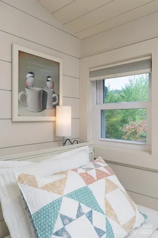 a view of a bedroom with a bed and a window