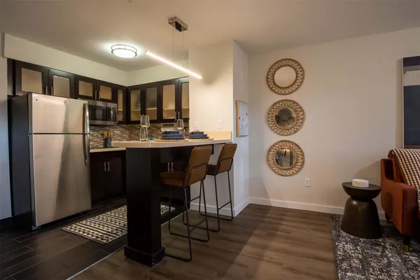 a kitchen with a refrigerator a stove top oven a clock and a window