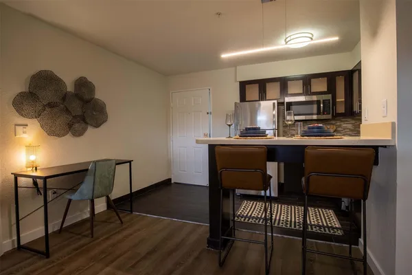 a kitchen with a dining table chairs and white cabinets