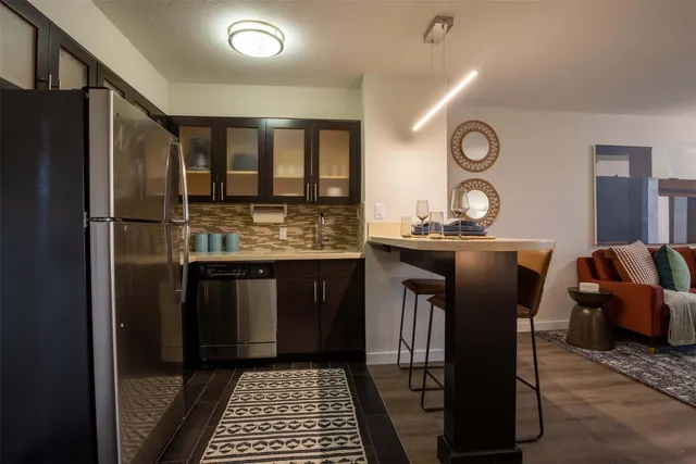 a kitchen with stainless steel appliances granite countertop a refrigerator a stove and a sink