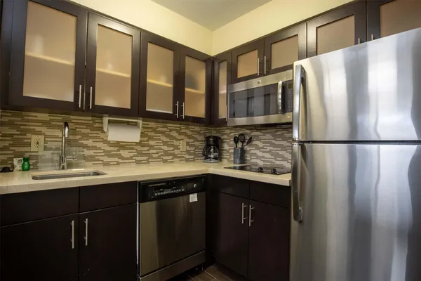 a kitchen with stainless steel appliances granite countertop a sink and a refrigerator