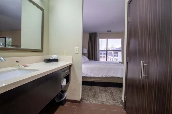 a en suite bathroom with a granite countertop sink and a mirror
