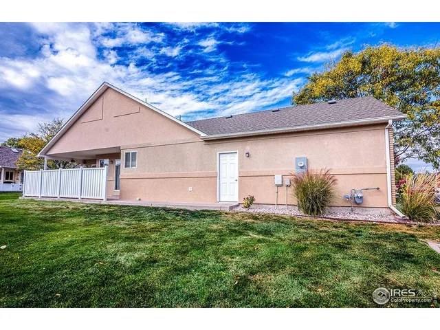 a backyard of a house with table and chairs