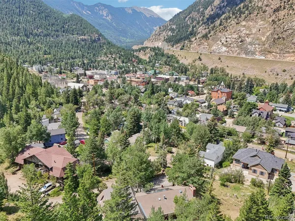 an aerial view of house with yard and mountain view in back