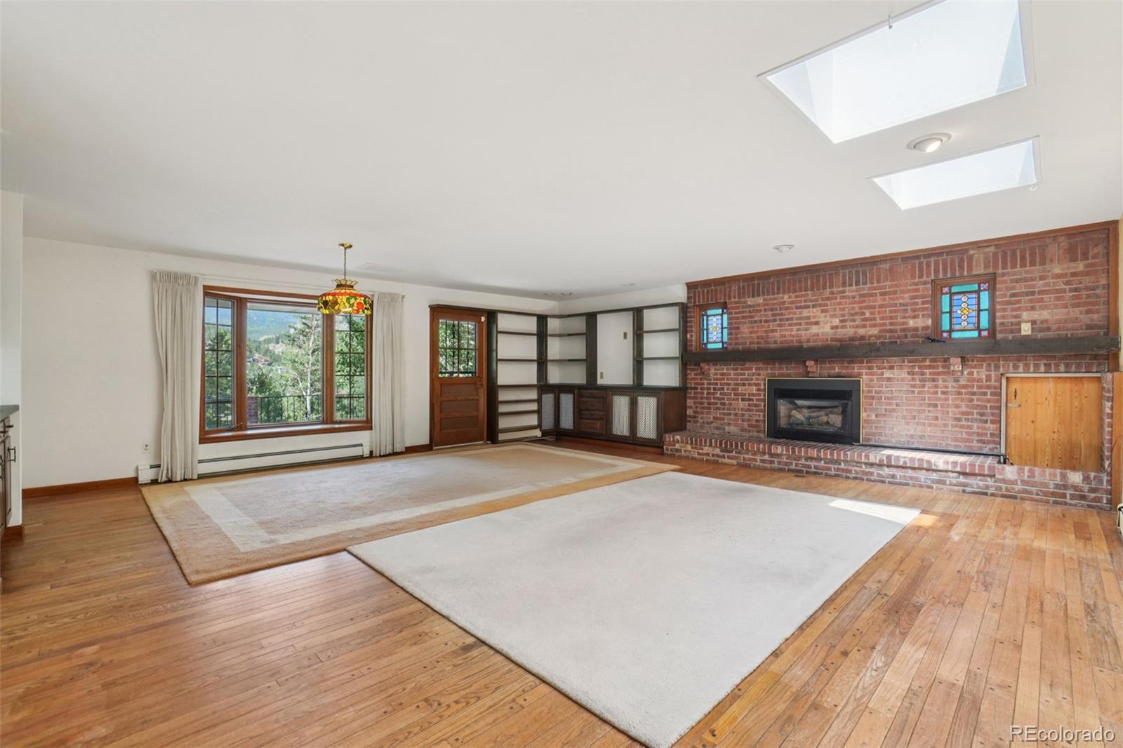 203 Ninth Street Georgetown, CO 80444 - Photo 22 of 44 an empty room with wooden floor and fireplace