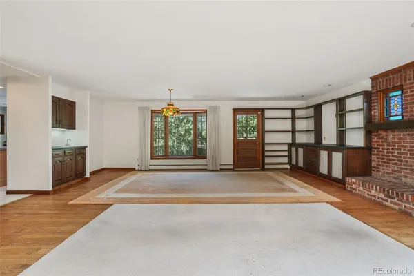 a view of an empty room with a fireplace and a window