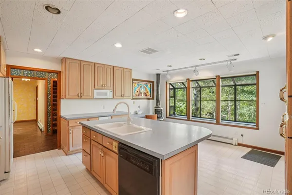 a kitchen with stainless steel appliances granite countertop a sink and a refrigerator
