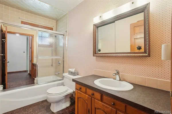 a bathroom with a granite countertop sink toilet and shower