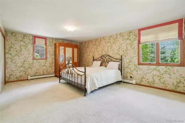 a bed sitting in a spacious bedroom next to a window
