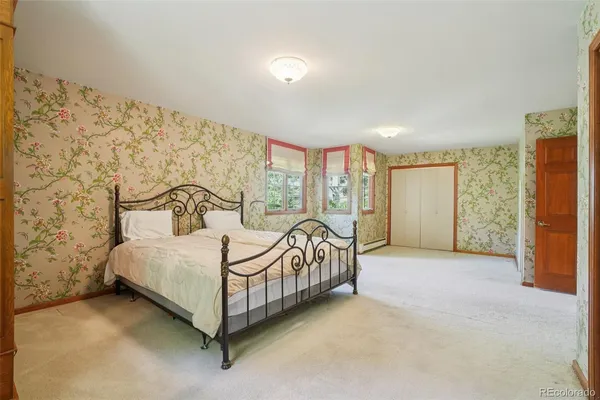 a bed sitting in a spacious bedroom next to a window