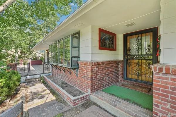 a view of a brick house with a small yard and wooden floor and fence