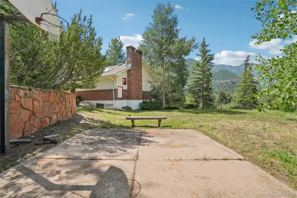 a view of a house with backyard and trees
