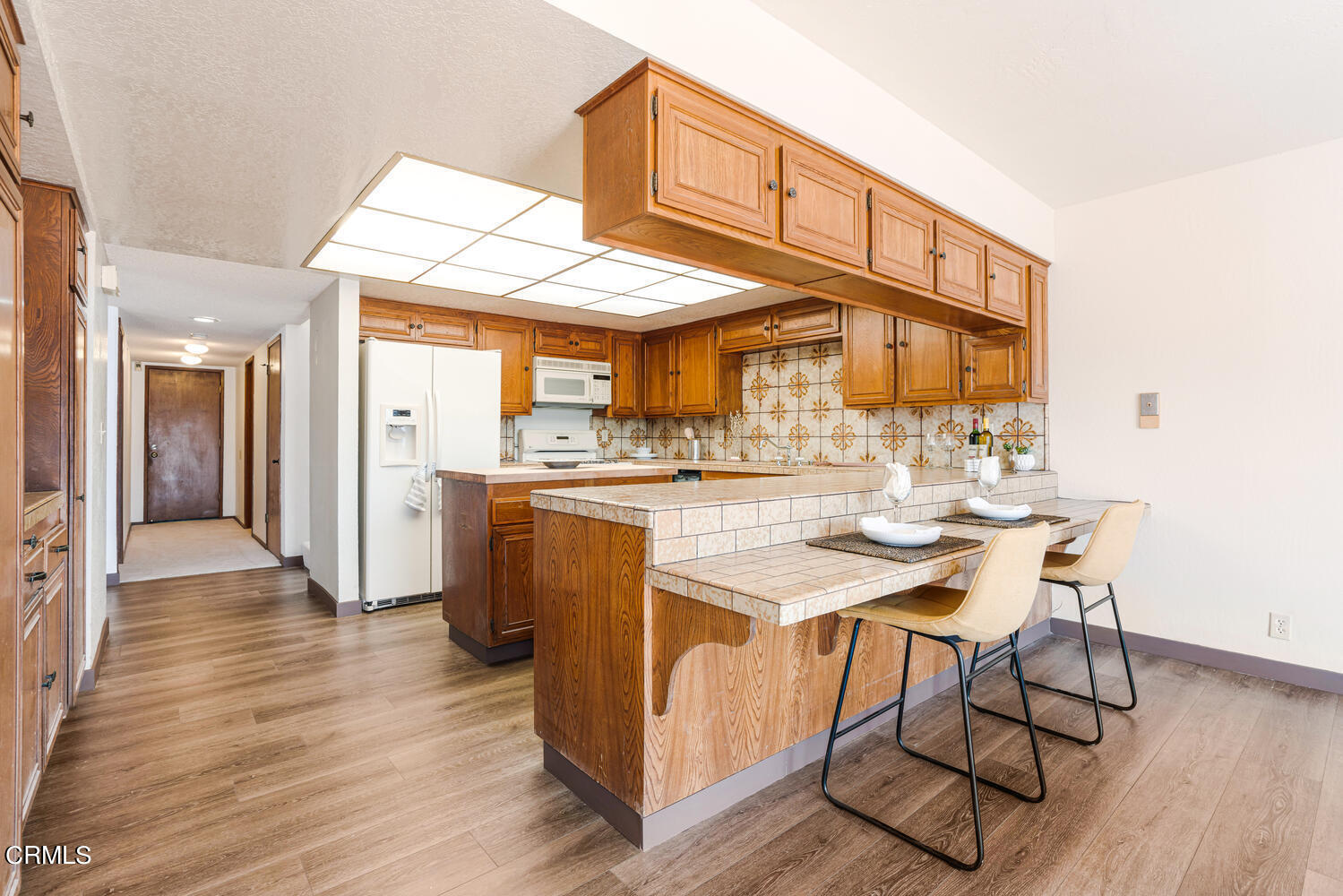 2101 Napoli Drive Oxnard, CA 93035 - Photo 17 of 50 a kitchen with stainless steel appliances kitchen island a table chairs in it and wooden floors