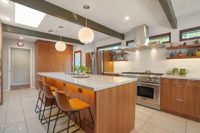 a kitchen with stainless steel appliances a stove a sink and a refrigerator