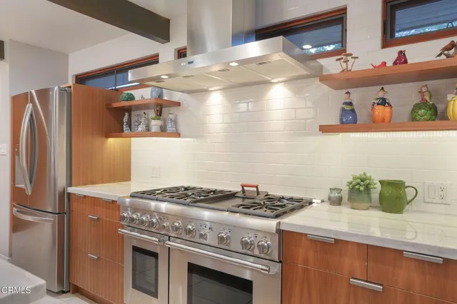 a kitchen with stainless steel appliances granite countertop a stove and a refrigerator