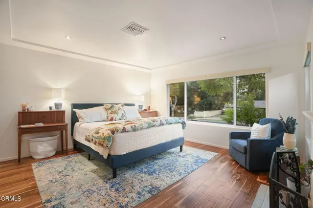 a spacious bedroom with a bed and glass window