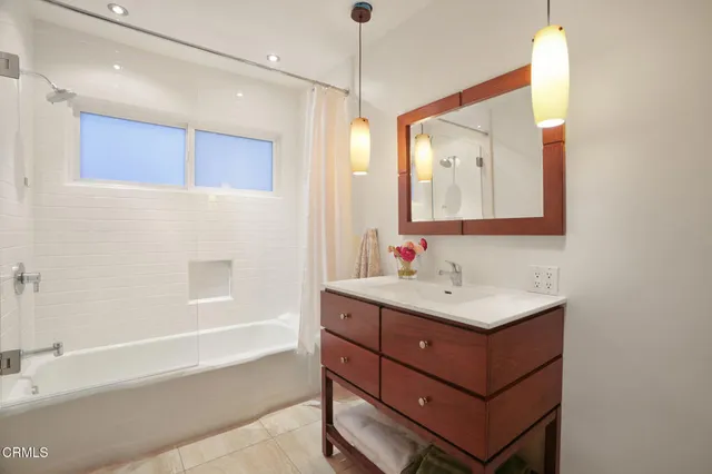 a bathroom with a sink mirror and a bathtub