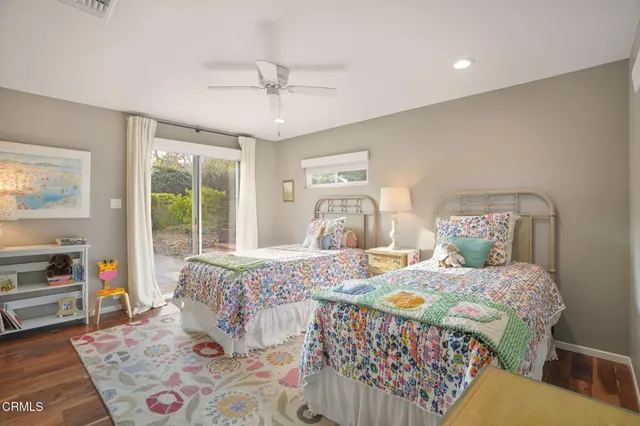 a bedroom with a bed a dresser and a large window