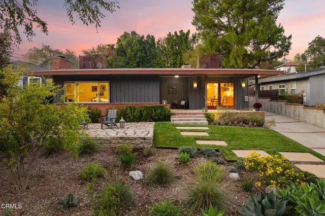 a front view of a house with a yard and a garden