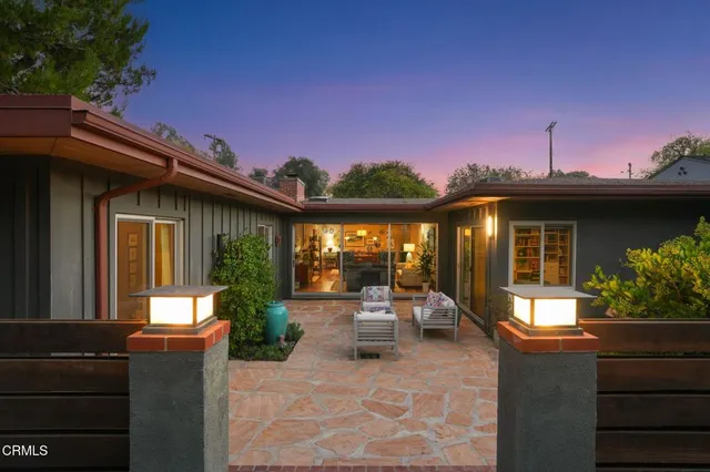 a view of a house with sitting area and garden