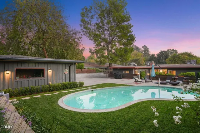 a view of a house with backyard sitting area and garden