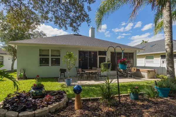 a front view of a house with a yard and potted plants
