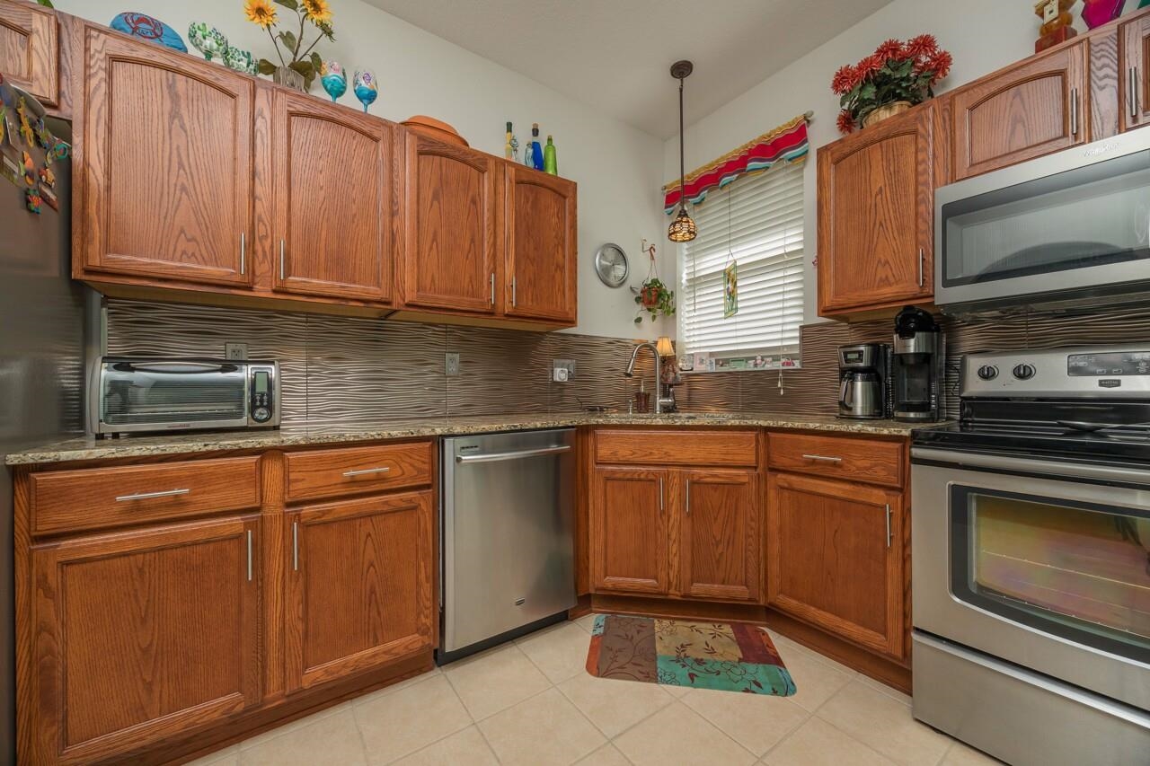 1041 Ridgewood Lane St. Augustine, FL 32086 - Photo 23 of 40 a kitchen with stainless steel appliances granite countertop a sink stove and cabinets