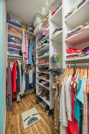 a view of walk in closet with clothes and shoes