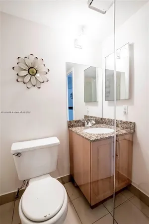 a bathroom with a granite countertop toilet sink and mirror