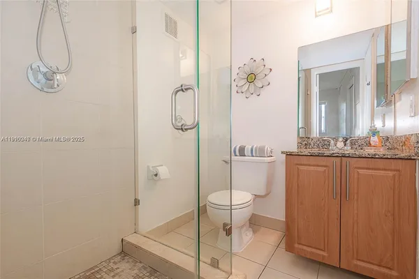 a bathroom with a granite countertop sink a toilet and shower